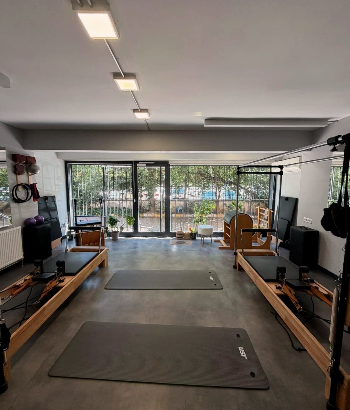 Pol Pilates Studio ana salonu, ahşap reformerlar ve cam cepheden gelen gün ışığı